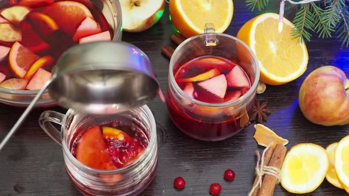 自制热酒，在家煮热酒。加入橙子、苹果和香料。传统饮料在冬季，为圣诞节和新年假期。汤料倒入锅中，用汤勺