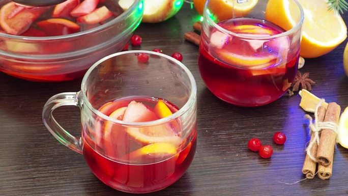 自制热酒，在家煮热酒。加入橙子、苹果和香料。传统饮料在冬季，为圣诞节和新年假期。汤料倒入锅中，用汤勺