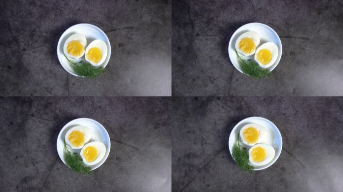 两个半煮鸡蛋与新鲜的香草在一个白色的碟子-俯瞰4K