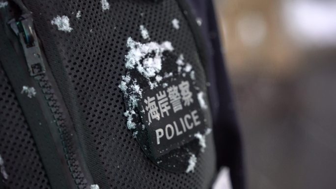 雪花落在海岸警察警服标识上
