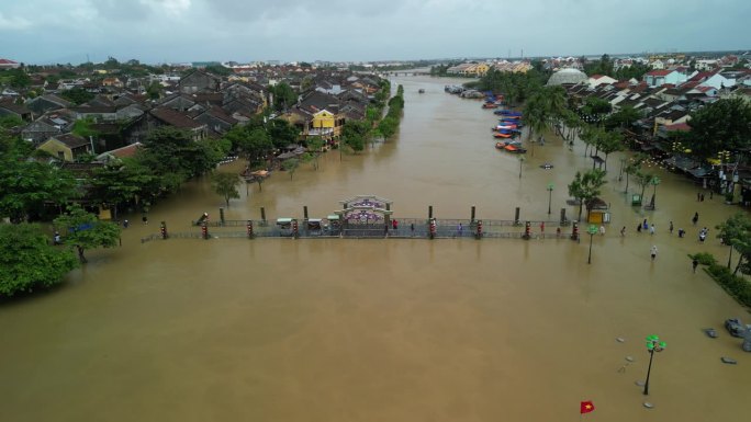 无人机拍摄的越南广南会安洪水后人们在被水淹没的街道上行走的画面