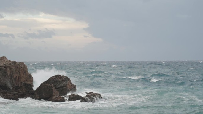强烈的海浪撞击着高高的悬崖，可以看到蓝色的天空，但风暴还没有结束。