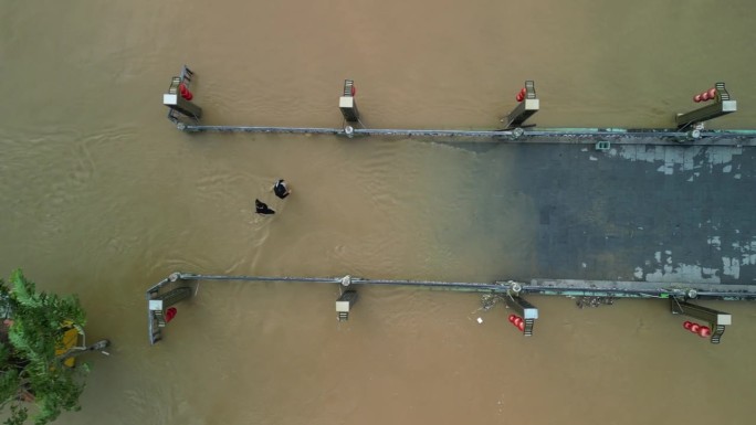 无人机拍摄的越南会安镇洪水后人们在被水淹没的街道上行走的画面