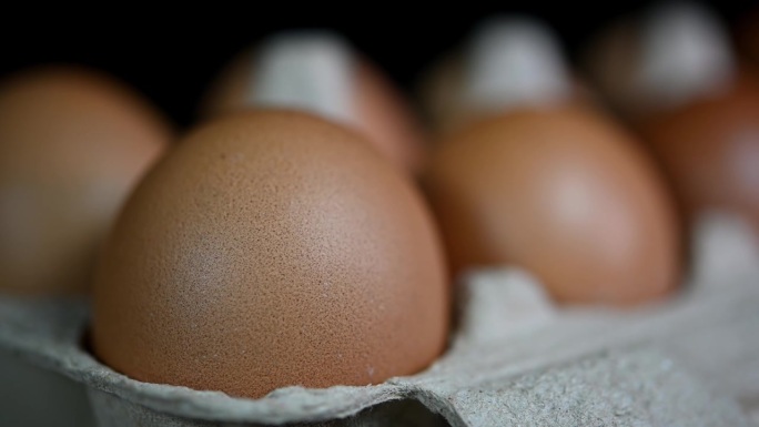 镜头变焦显示了一打鸡蛋放在纸做的托盘里，食物和烹饪。
