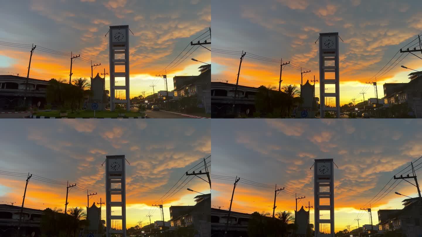 日落时分，在泰国庄省的一个小城市，钟楼上的奶妈云