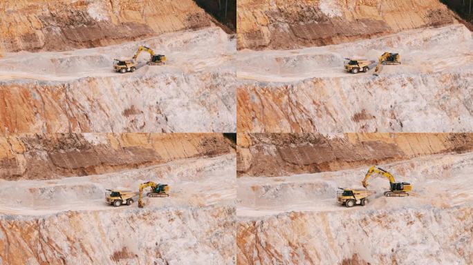 空中无人机拍摄的挖掘机装载矿物到露天矿坑自卸卡车