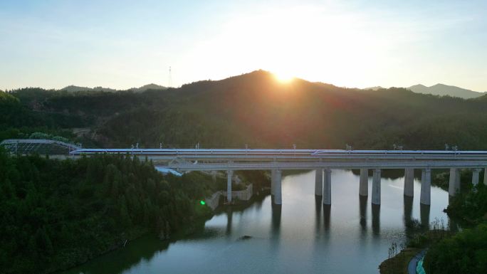 夕阳下经过桥梁的高铁动车