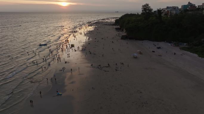 夕阳下的涠洲岛海滩人群