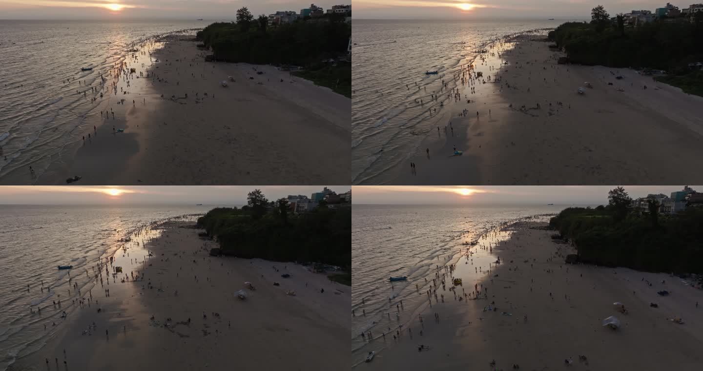 夕阳下的涠洲岛海滩人群