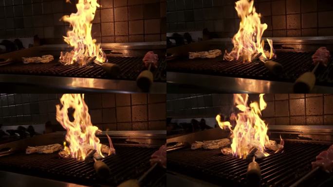 厨师在厨房烤架上明火烹调肉类特写。美味和多汁的肉烤烤鸡慢动作。准备烧烤食物的厨师。新鲜的烧烤餐在燃烧