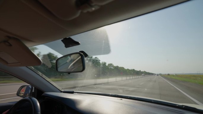 从高速公路上驾驶的汽车内看。在道路上行驶的挡风玻璃车辆