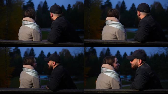 幸福的情侣在秋天的公园里荡秋千聊天