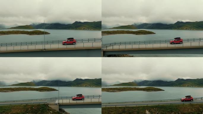 航拍侧视图，红色SUV轿车行驶在美丽的北欧景色的背景