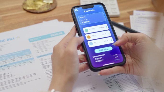 近距离双手妇女使用智能手机支付与非接触式支付和银行应用程序支付在线水电费支付，网上银行技术和资金转移