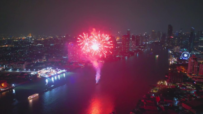 空中无人机的视角多色烟花表演在天空之城。除夕夜。摩天大楼和城市景观庆祝夜晚的灯光