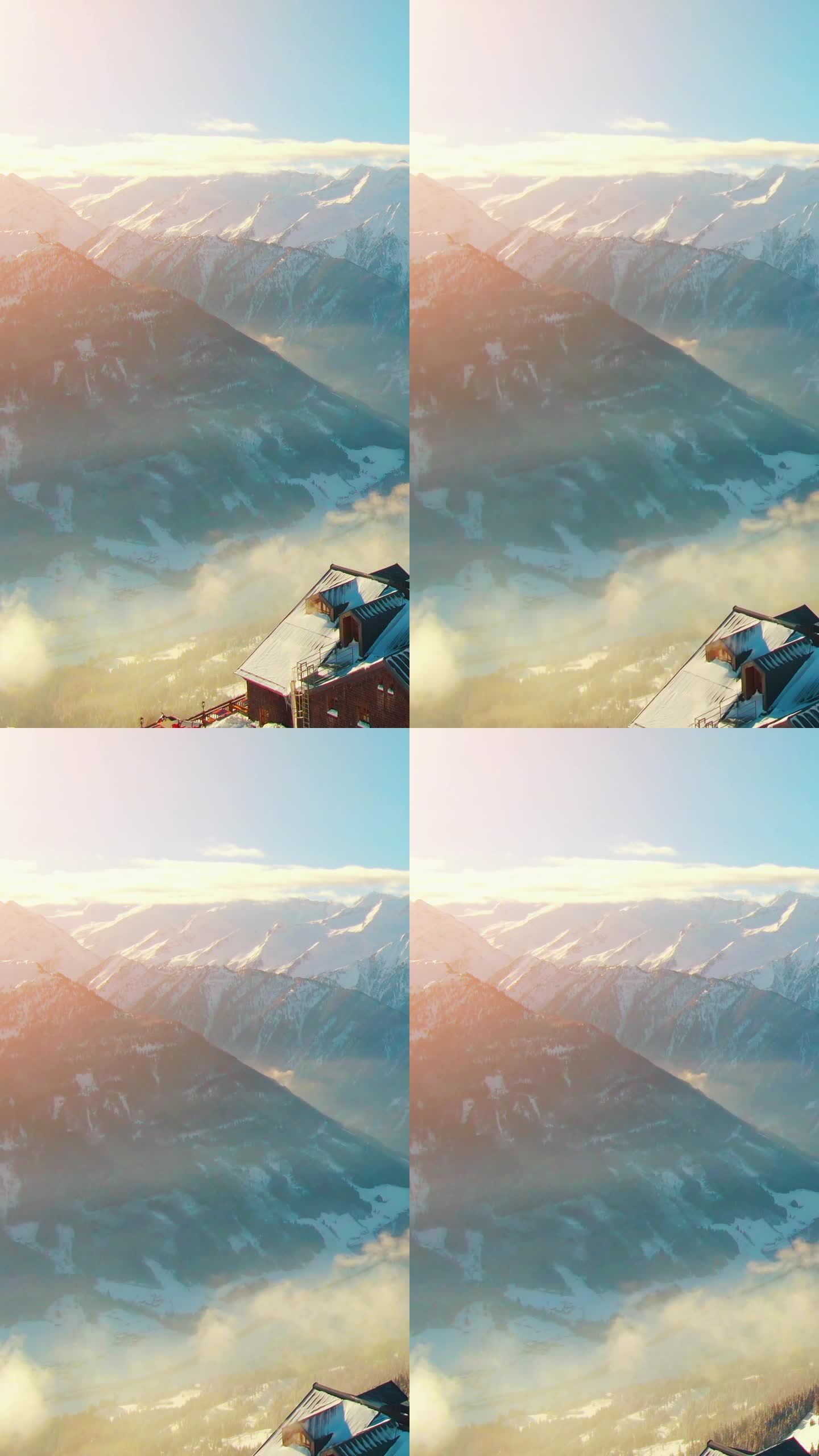 在一个阳光明媚的下午，空中直升机拍摄了宁静的乡村山区景观，白雪覆盖的山峰和奥地利阿尔卑斯山的滑雪胜地