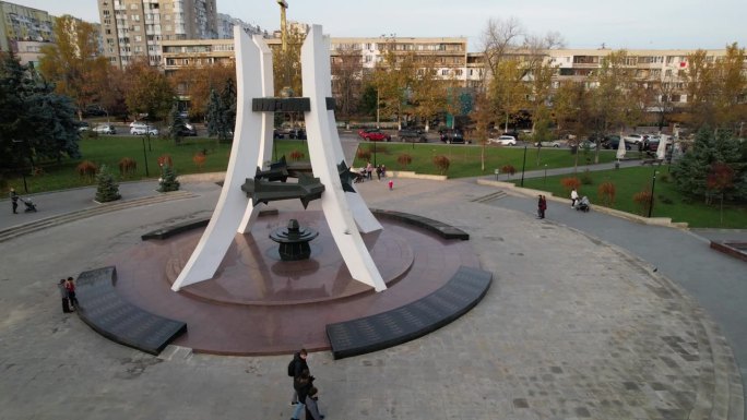 在阿富汗苏联战争中牺牲的摩尔多瓦士兵纪念碑的全景空中无人机视图。多处办公楼，住宅楼，背景中有汽车行驶