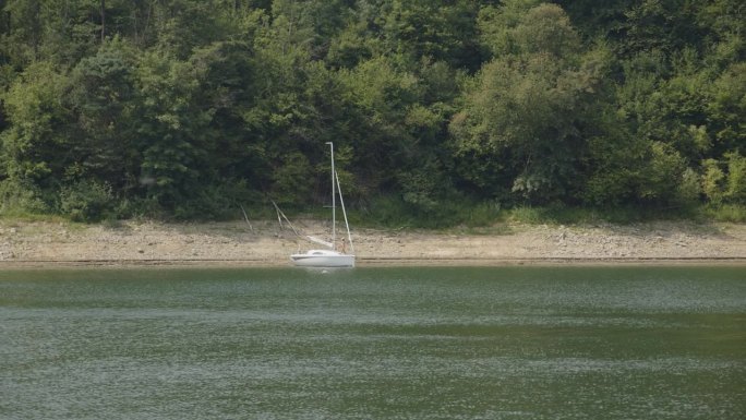暑假在湖边。帆船停泊在海滩边