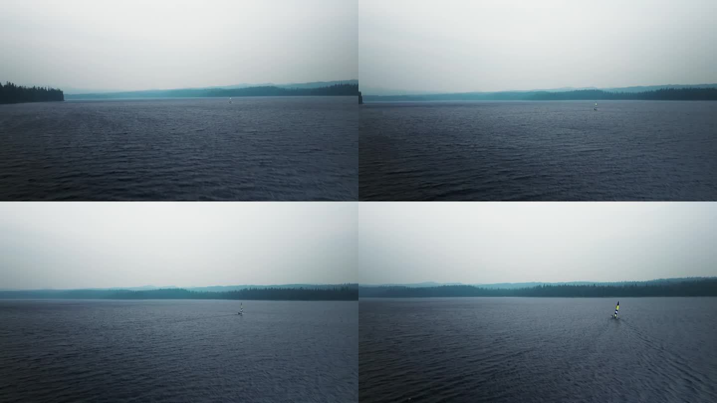 航拍摄影在雾蒙蒙的寒冷的湖太阳鱼帆船在风吹水