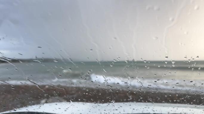窗外雨点清晰可见，窗外波涛汹涌的海景沿海