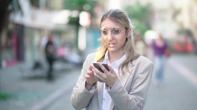 智能手机使用面部识别系统解锁。作为一项安全措施，正在扫描一个女人的脸。人脸检测点。