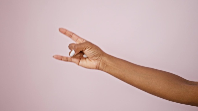 非裔美国妇女用手在孤立的粉色背景上做喇叭手势
