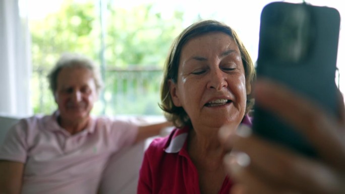 老妇人进行视频通话-与远方的家人联系，奶奶用智能手机视频聊天拉近距离，与亲戚交谈