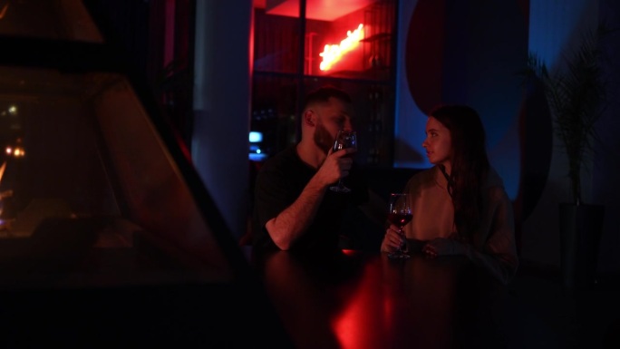 一对浪漫的情侣坐在壁炉旁，喝着红酒