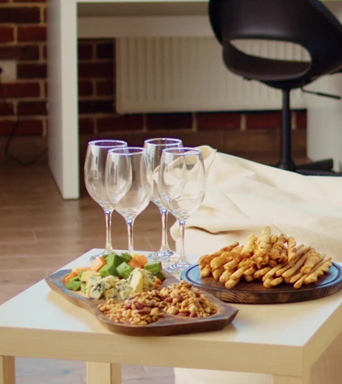 垂直视频空时尚舒适的公寓客厅饼干，花生和奶酪在熟食板