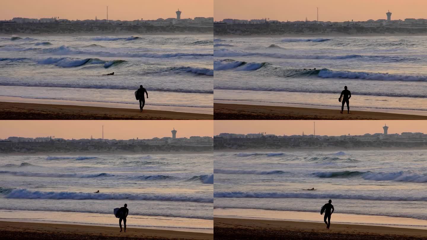 漫步在葡萄牙大西洋海岸沙滩上的匿名冲浪者