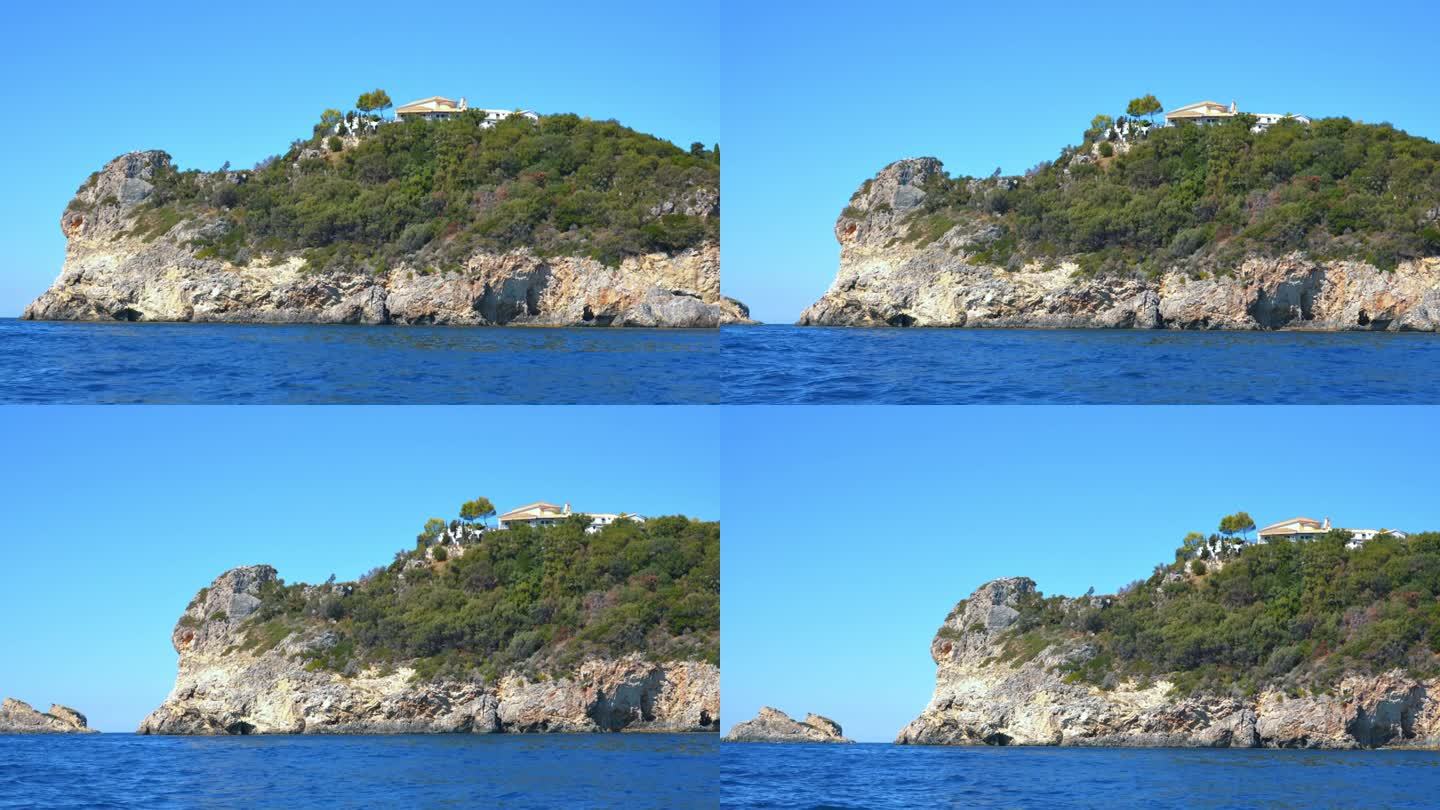在水面上可以看到尖锐的高大的岩石悬崖——希腊科孚岛古奥卡斯特里萨附近的典型海景，从船上看，可以看到山