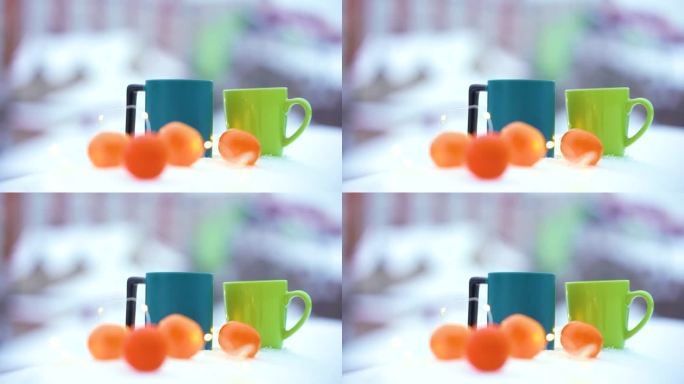 圣诞理念:一杯茶，雪中的橘子和一个花环。冬天的晚上,