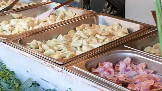 许多不同口味的波兰传统经典饺子有不同的馅料出售，金属容器美食节市场摊位，餐厅服务。本土厨房饮食文化理