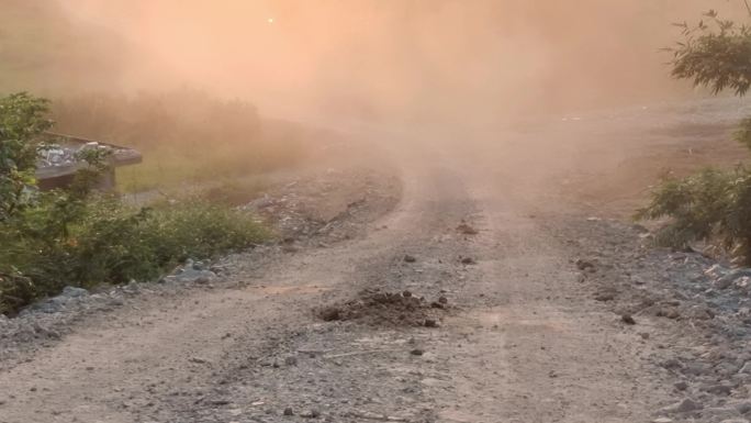 夕阳西下逆光尘飞扬山坡泥巴路灰尘沙尘暴灰