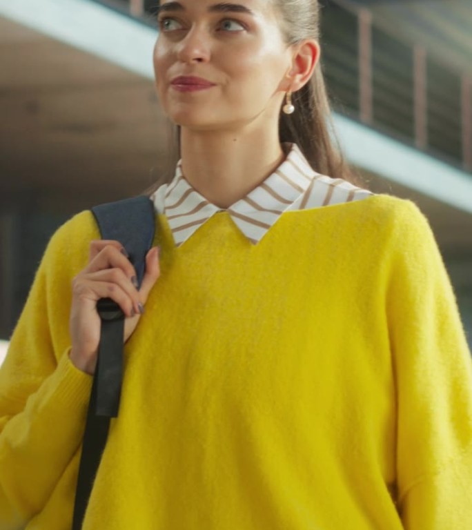 垂直屏幕:美丽的女学生走在一个空的公共图书馆的书架。年轻聪明的女人背着装有课本的背包准备和学习考试。