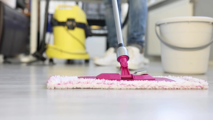清洁工用拖把刷洗公寓地板