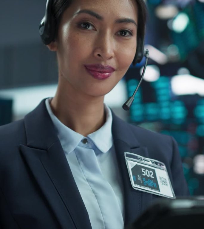 竖屏:在国际证券交易大厅工作的亚洲美女;戴着耳机使用平板电脑的专业人士;看着镜头微笑的成功交易者