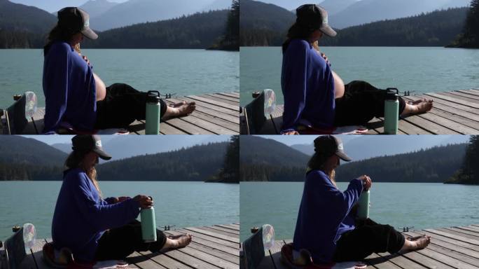 年轻的孕妇在湖上的木码头上休息