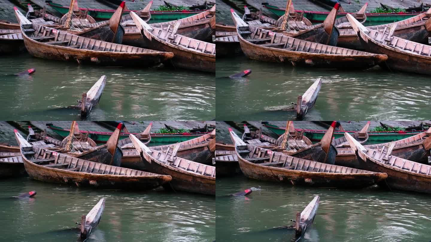 传统的木筏船在被污染的河流在达卡码头，孟加拉国。鱼跳