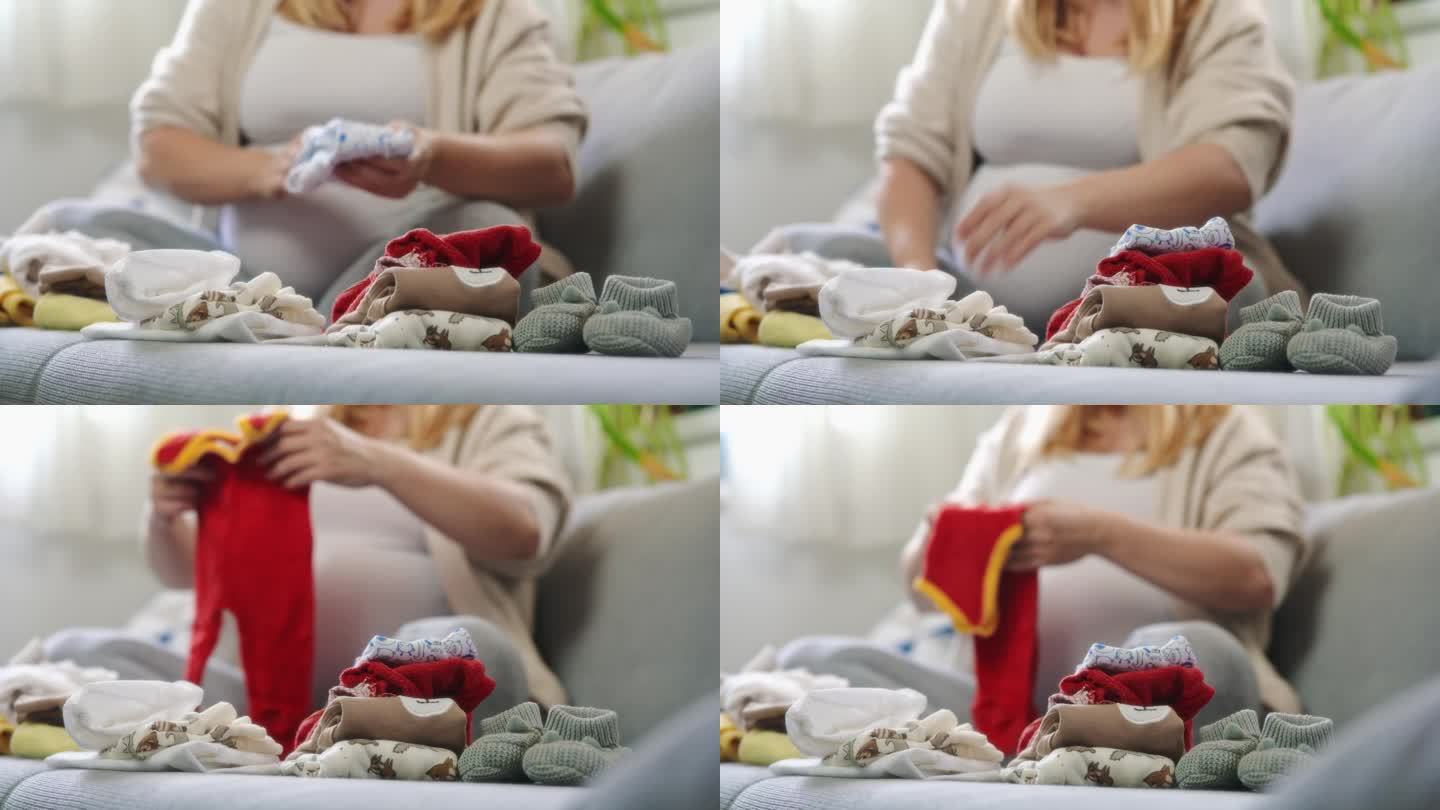 孕妇在客厅沙发上叠可爱的婴儿衣服