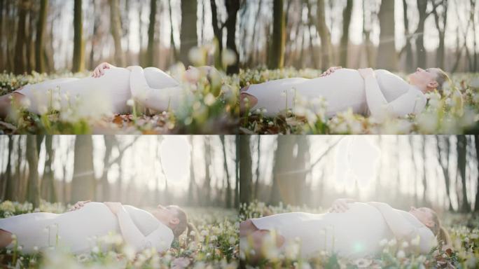 安详的孕妇躺在阳光明媚的树林里的花丛中