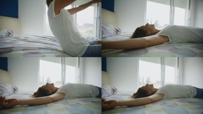 一个愉快的女人躺在家里的床上，伸开双臂
