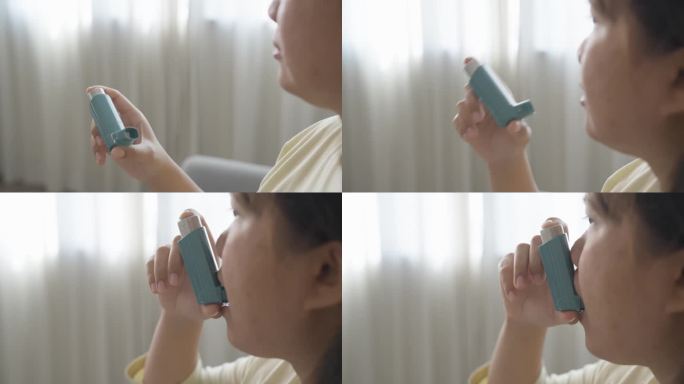 亚洲妇女在家使用哮喘吸入器的特写