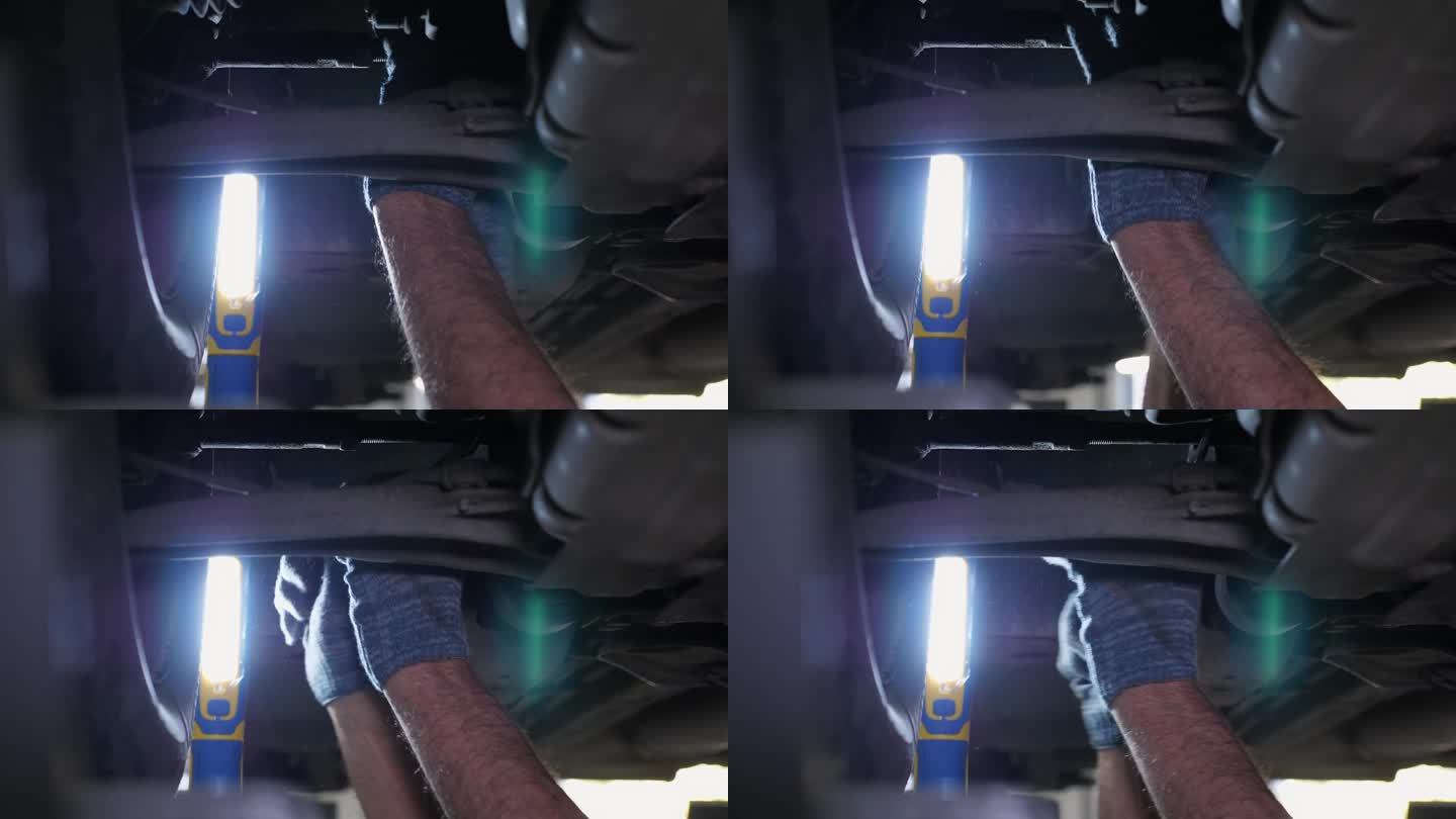 汽车修理工用扳手拧开汽车底部的螺帽。