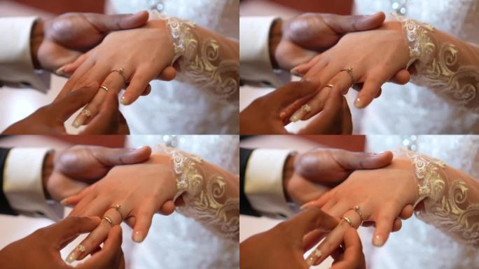 新郎在婚礼上给新娘戴上结婚戒指。婚礼的细节。
