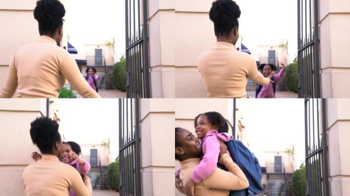 第一天上学后，漂亮的黑人小女孩在学校门口跑向妈妈的怀抱，看起来非常兴奋和快乐