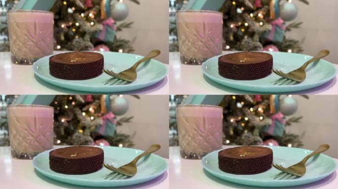 巧克力南瓜香料拿铁可可奶昔巧克力蛋糕在一个蓝色的盘子新年的圣诞树闪烁的灯广告金色的叉子反射的光在一个