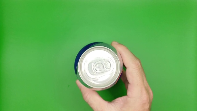 男人的手放在绿色背景的啤酒罐上。