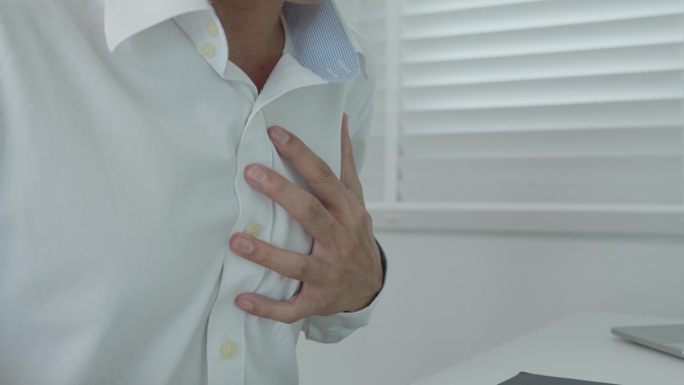 手握胸脯有心脏病发作的症状，亚洲人工作辛苦有胸痛引起的心脏病，漏、扩张、冠状动脉增大，压在胸口有疼痛