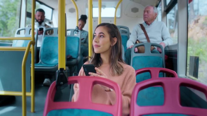 女性在公交车上带着手机阅读，或者在城市通勤时开车时带着手机应用。公共交通，服务或乘车，女孩在上班路上